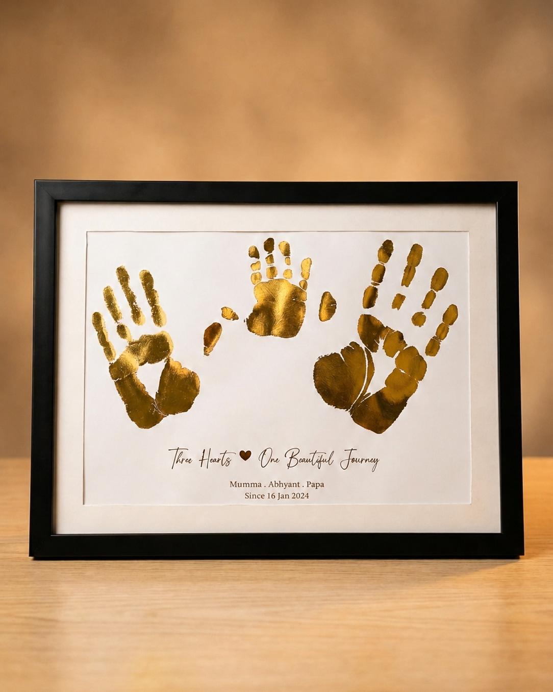 Baby hands with parents hand in gold foil
