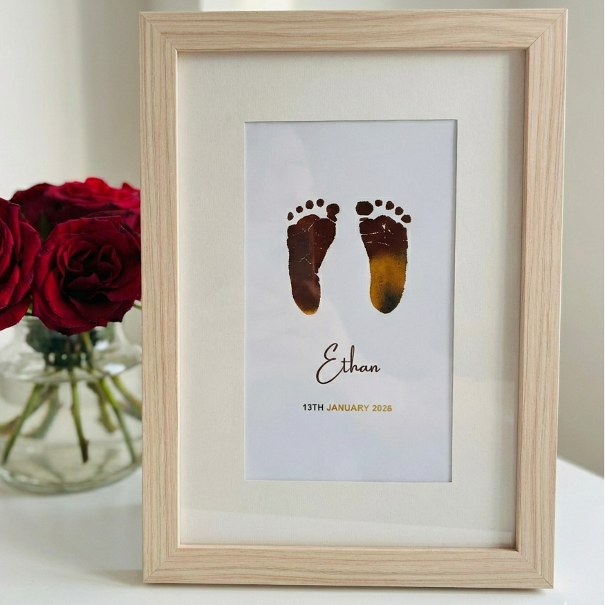 Framed gold print with baby footprints and name