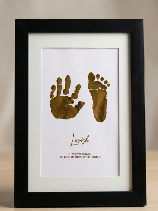 Framed print with gold hand and footprints and text on a beige background
